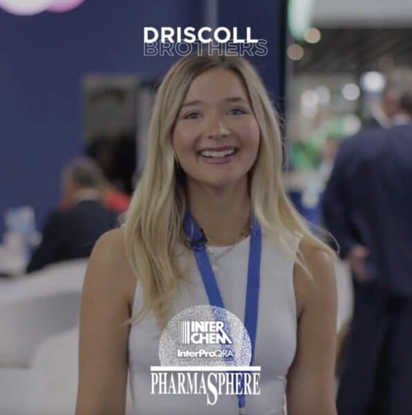 A picture of Ariela Pizza in the PharmaSphere booth giving her testimonial with the PharmaSphere logo and Driscoll Brothers logo
