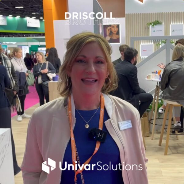 A picture of Julie Carnes in the Replin booth giving her testimonial with the Univar logo and Driscoll Brothers logo